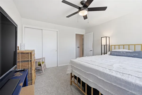 a bedroom with a bed and a flat tv screen on dresser