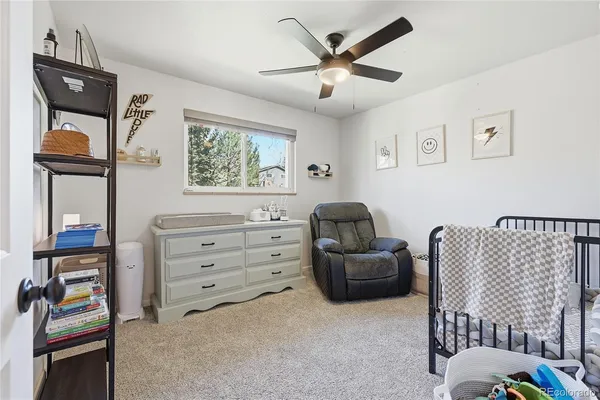 a livingroom with a baby crib furniture and a window
