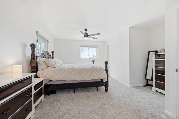 a bedroom with a bed and a ceiling fan