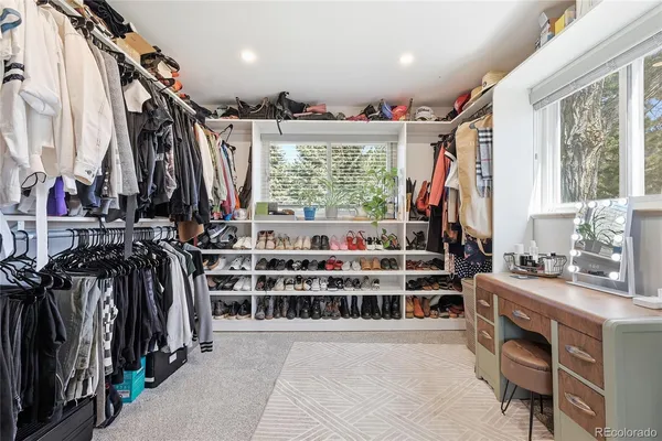 a view of walk in closet with clothes and shoes