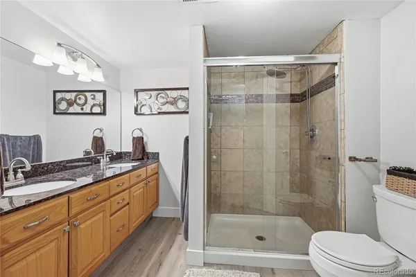 a bathroom with a double vanity sink toilet and shower