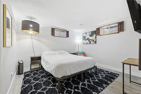 a bedroom with a bed and a lamp next to a window