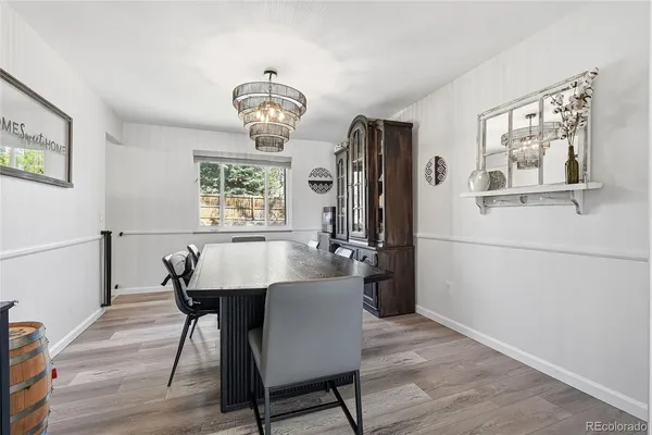 a view of a dining room with furniture a chandelier and wooden floor