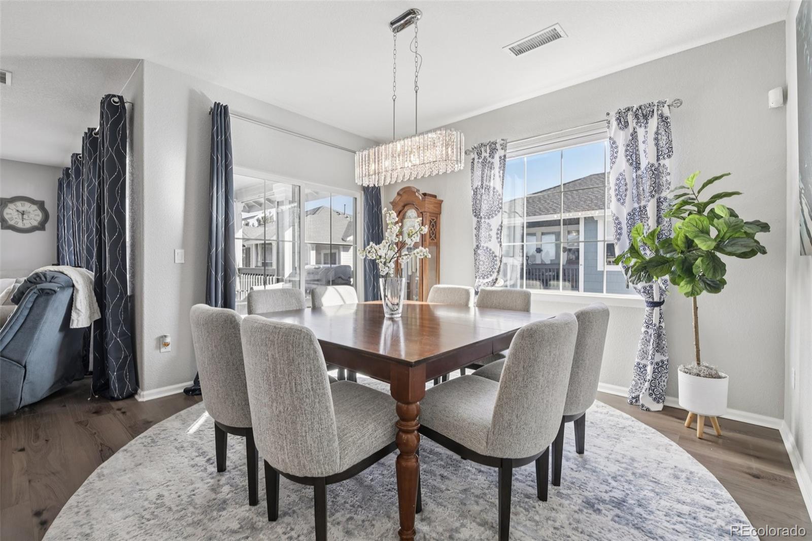 224 Whitehaven Circle Highlands Ranch, CO 80129 - Photo 9 of 34 a dining room with furniture potted plants and wooden floor
