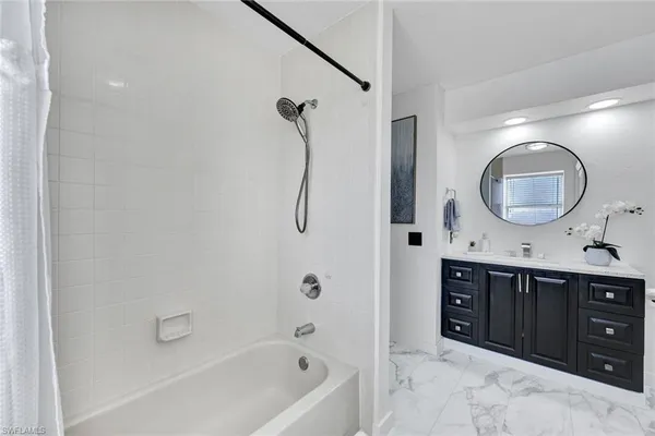 a spacious bathroom with a tub sink and mirror