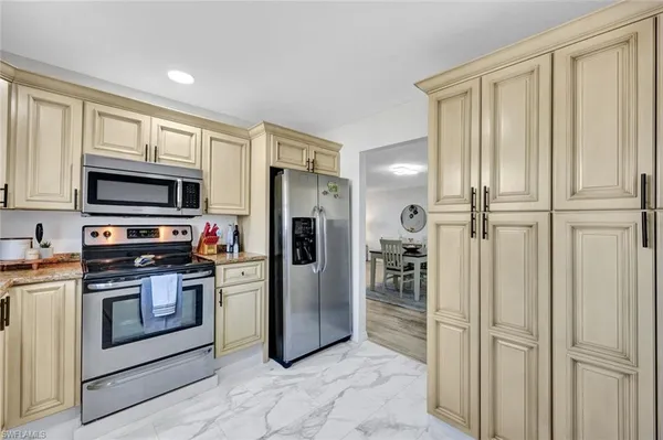 a kitchen with stainless steel appliances granite countertop a refrigerator and a stove top oven