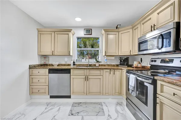 a kitchen with stainless steel appliances granite countertop a stove and cabinets