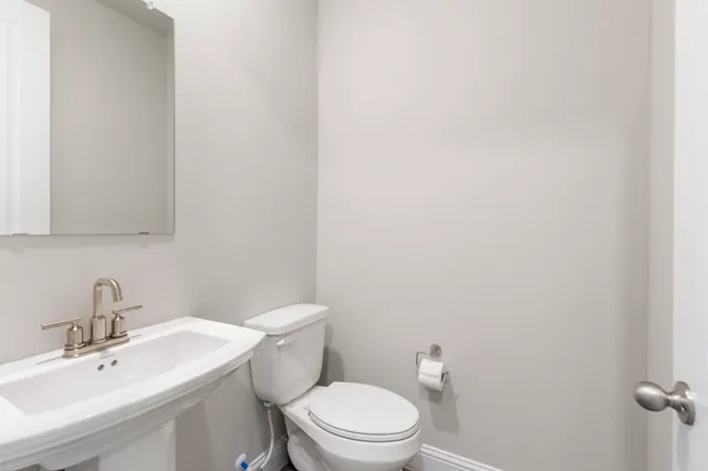 a white toilet sitting next to a bathroom sink