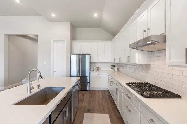 a kitchen with stainless steel appliances granite countertop a sink stove and refrigerator