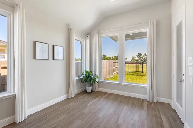 an empty room with window and wooden floor
