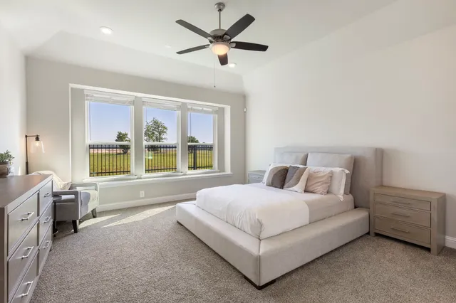 a spacious bedroom with a bed and a large window