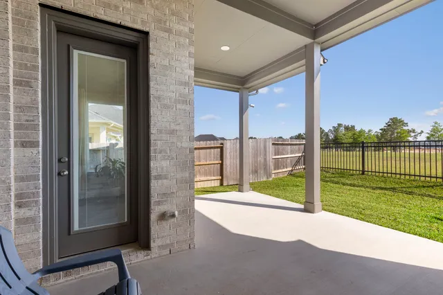 a view of a porch with a floor to ceiling window and a yard