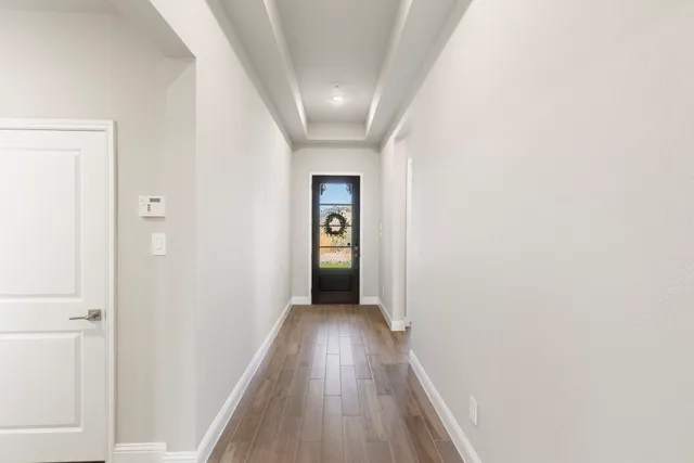 a view of a hallway with wooden floor