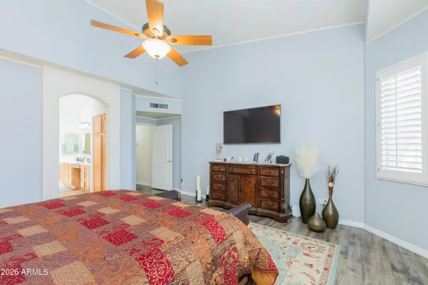 a bedroom with a bed a flat screen tv and dresser