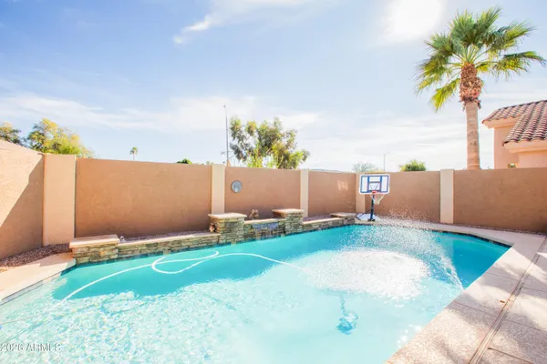 a view of backyard with swimming pool and outdoor seating