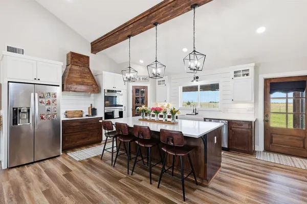 a large kitchen with a table and chairs
