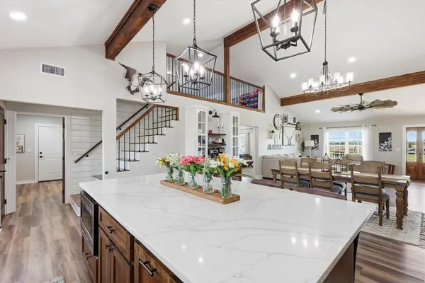 a room with lots of white furniture and wooden floor
