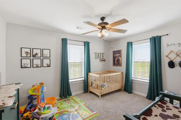 a living room with baby crib furniture and a window
