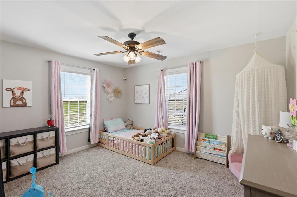 2201 South Road Whitesboro, TX 76273 - Photo 30 of 40 a bedroom with a bed and a chandelier