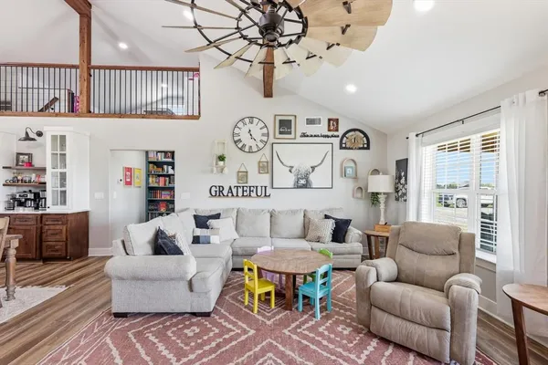 a living room with furniture and a wooden floor