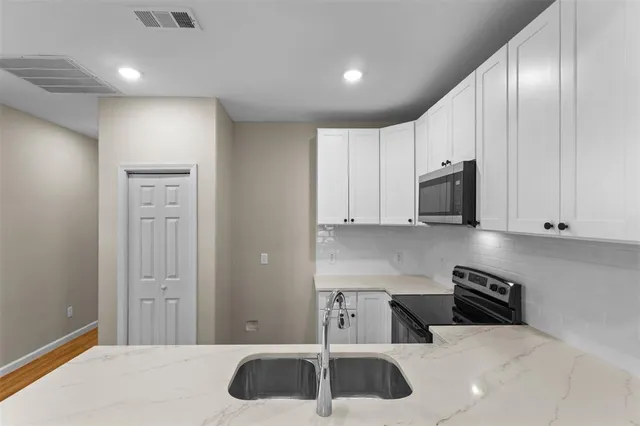 a kitchen with stainless steel appliances white cabinets and a sink