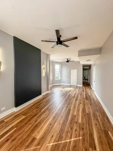 a view of a livingroom with wooden floor and a ceiling fan