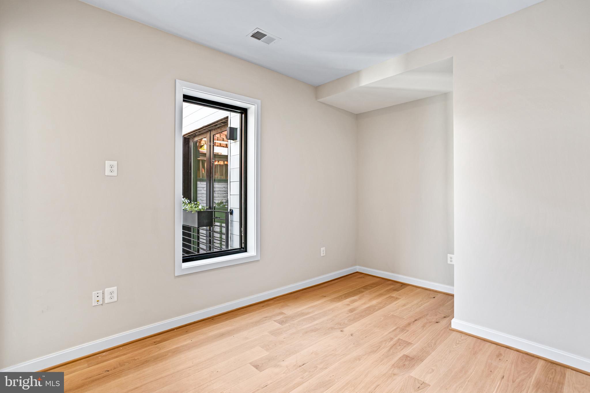 1402 12th Street Northwest, Unit 10 Washington, DC 20005 - Photo 19 of 38 an empty room with wooden floor and windows