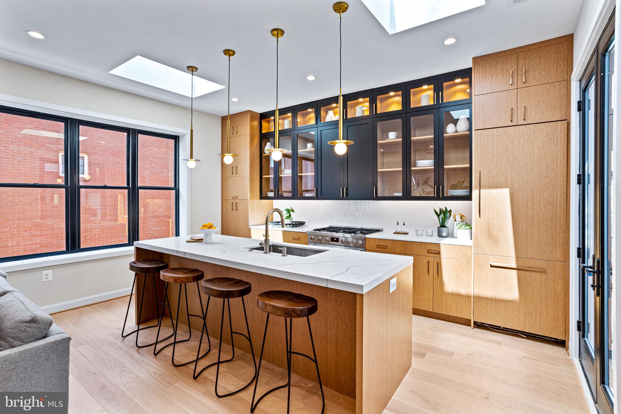 1402 12th Street Northwest, Unit 10 Washington, DC 20005 - Photo 9 of 38 a kitchen with stainless steel appliances granite countertop a stove a refrigerator and a table with wooden floor