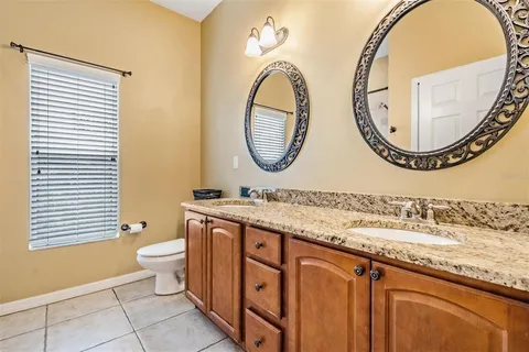 a bathroom with a granite countertop sink a mirror and a shower