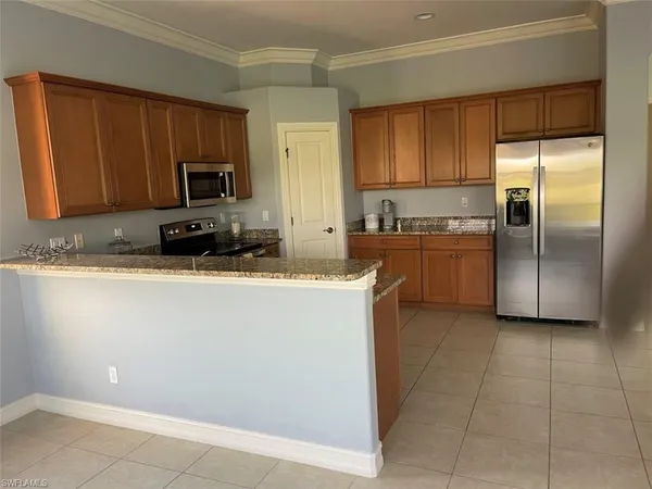 a kitchen with stainless steel appliances granite countertop a refrigerator a stove a sink and a microwave