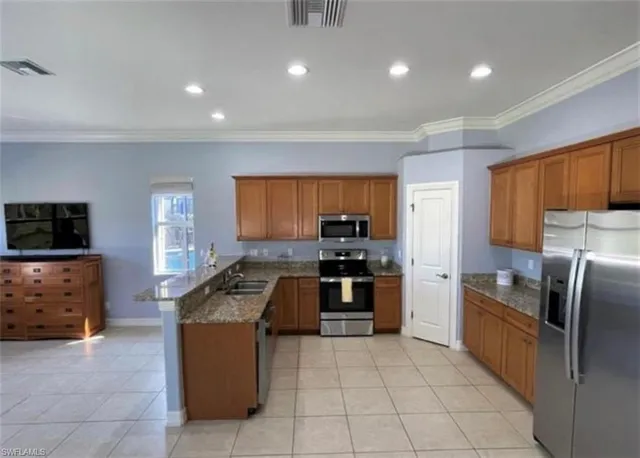 a kitchen with granite countertop a sink a counter top space appliances and cabinets