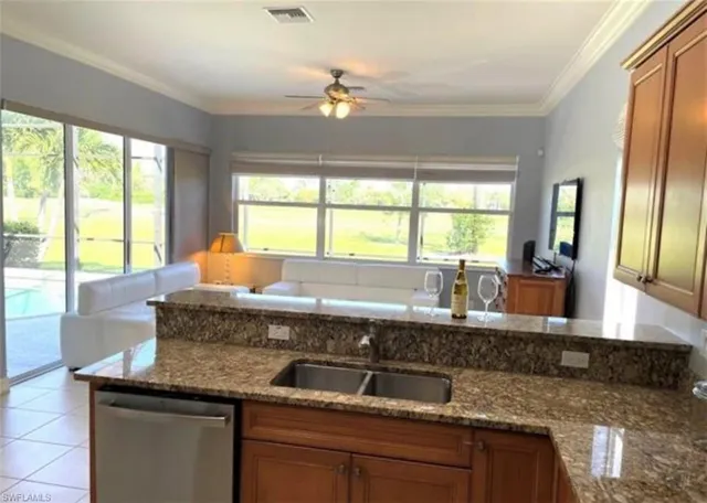 a kitchen with granite countertop a sink a counter top space and living room