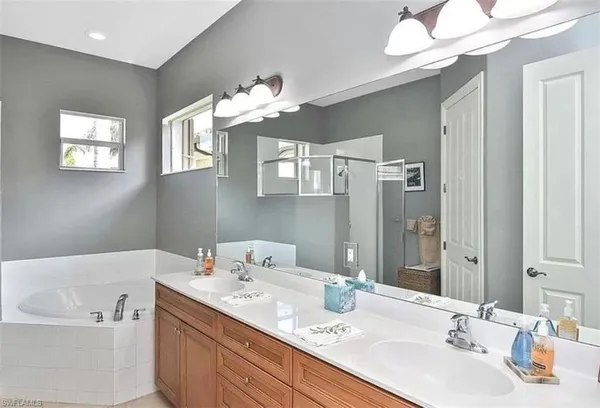 a bathroom with a sink a large mirror and a bathtub