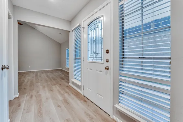 a view of a hallway with wooden floor and staircase