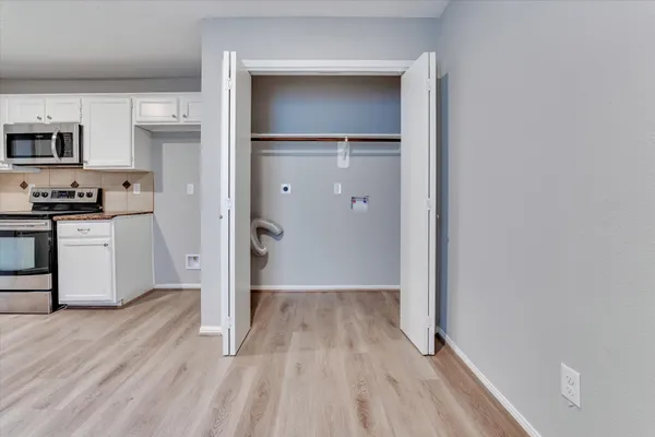 a view of a kitchen with wooden floor and a sink