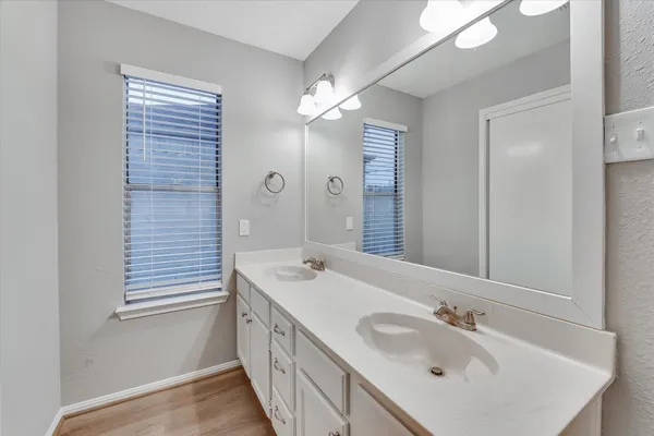 a bathroom with a double vanity sink and a mirror
