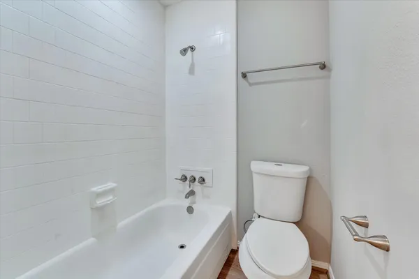 a white toilet sitting next to a bath tub