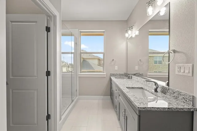 a bathroom with a granite countertop double vanity sink mirror and
