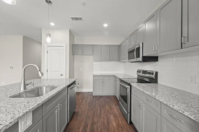 a kitchen with stainless steel appliances granite countertop a sink stove and refrigerator