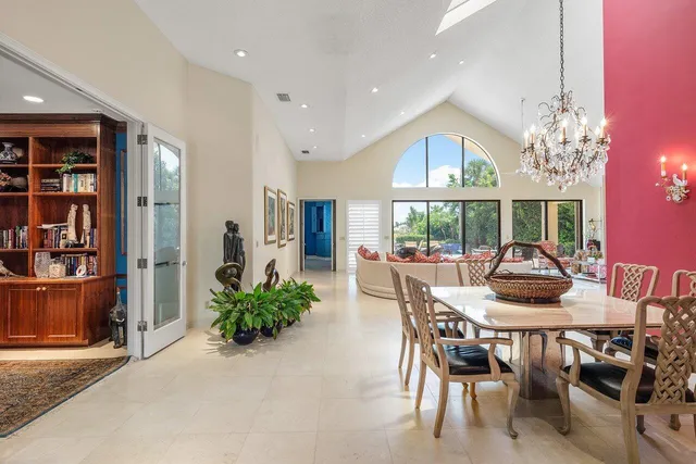 a dining room with furniture a large window and a potted plants