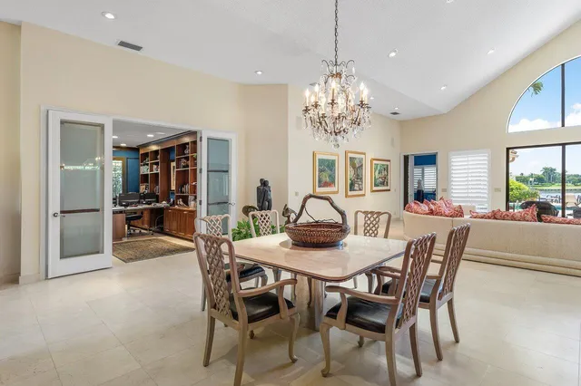 a living room with furniture a large window and potted plants