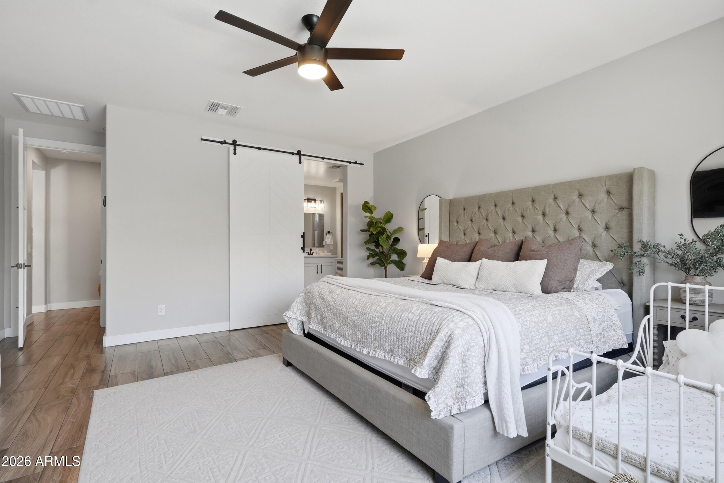 12517 West Lawrence Road Glendale, AZ 85307 - Photo 26 of 52 a spacious bedroom with a bed and a chandelier