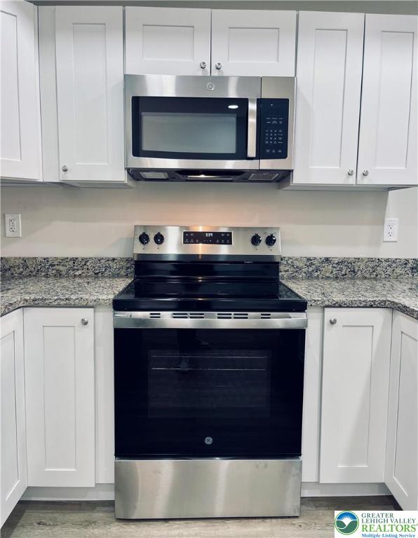 318 Barber Street, Unit LOT 33 Allentown, PA 18103 - Photo 19 of 53 a kitchen with stainless steel appliances granite countertop a stove and a microwave