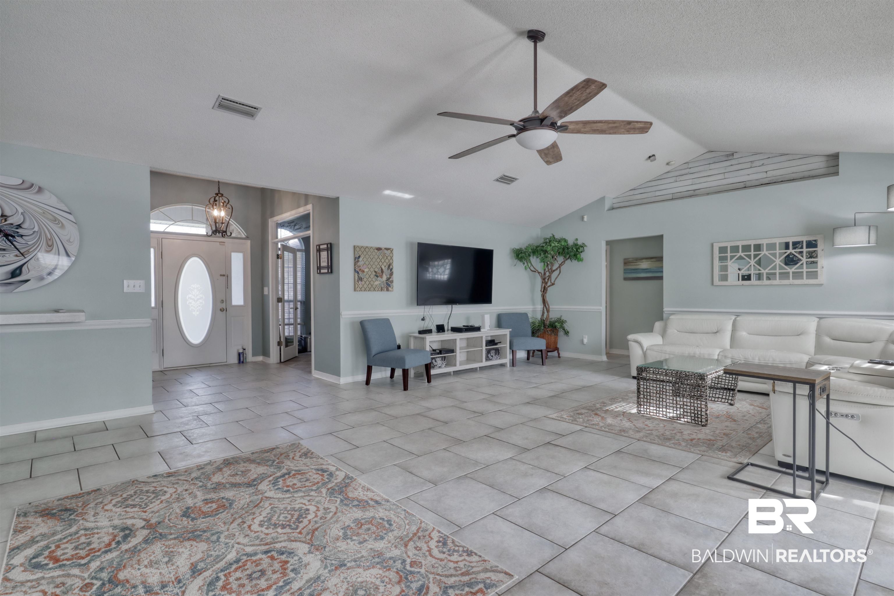 12893 Hunters Chase Foley, AL 36535 - Photo 18 of 42 Tiled living area with visible vents, a textured ceiling, vaulted ceiling, and ceiling fan