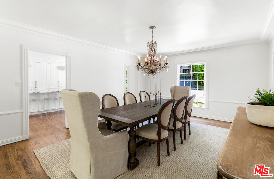 949 Stone Canyon Road Los Angeles, CA 90077 - Photo 11 of 41 a view of a dining room with furniture a chandelier and wooden floor