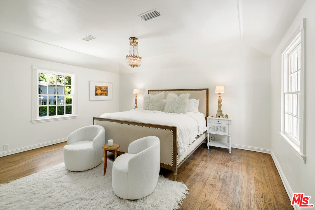 949 Stone Canyon Road Los Angeles, CA 90077 - Photo 22 of 41 a bedroom with a bed and wooden floor