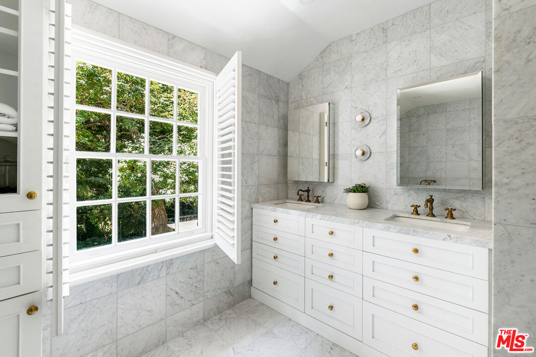 949 Stone Canyon Road Los Angeles, CA 90077 - Photo 24 of 41 a bathroom with a double vanity sink mirror and next to a window