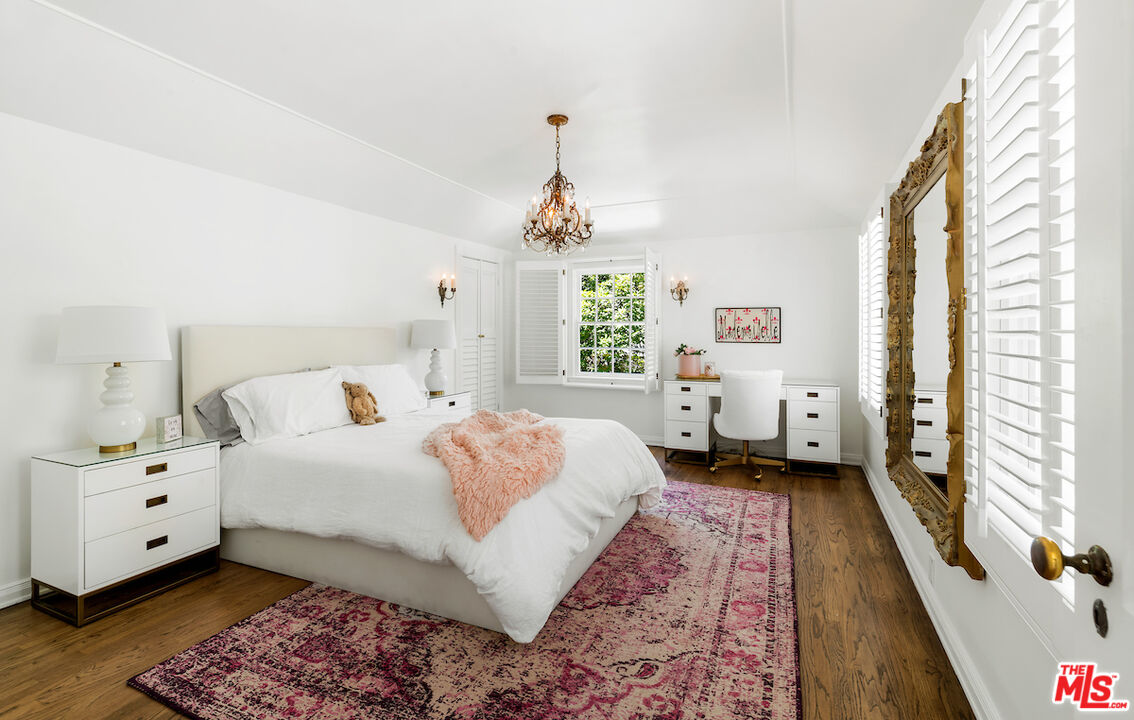 949 Stone Canyon Road Los Angeles, CA 90077 - Photo 30 of 41 a spacious bedroom with a bed chandelier and a window