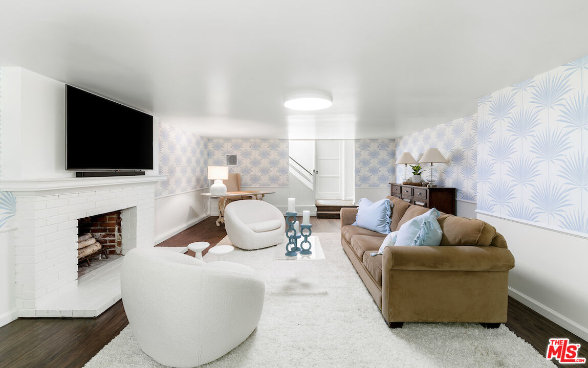 949 Stone Canyon Road Los Angeles, CA 90077 - Photo 32 of 41 a living room with furniture a fireplace and a flat screen tv