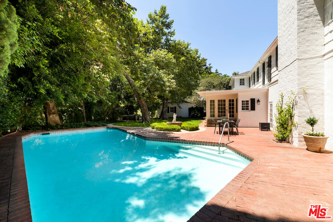 949 Stone Canyon Road Los Angeles, CA 90077 - Photo 38 of 41 a view of a swimming pool with sitting area and slide